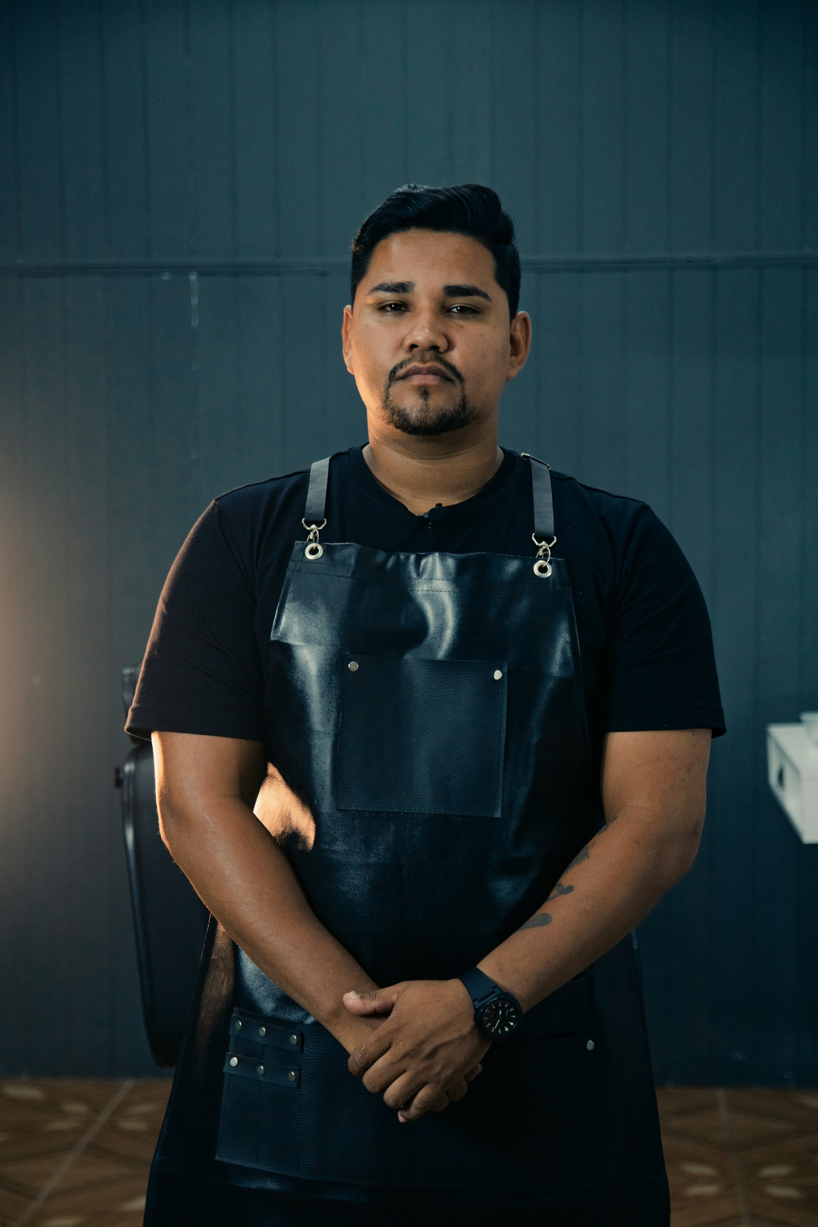 A business owner in a work apron standing in his shop