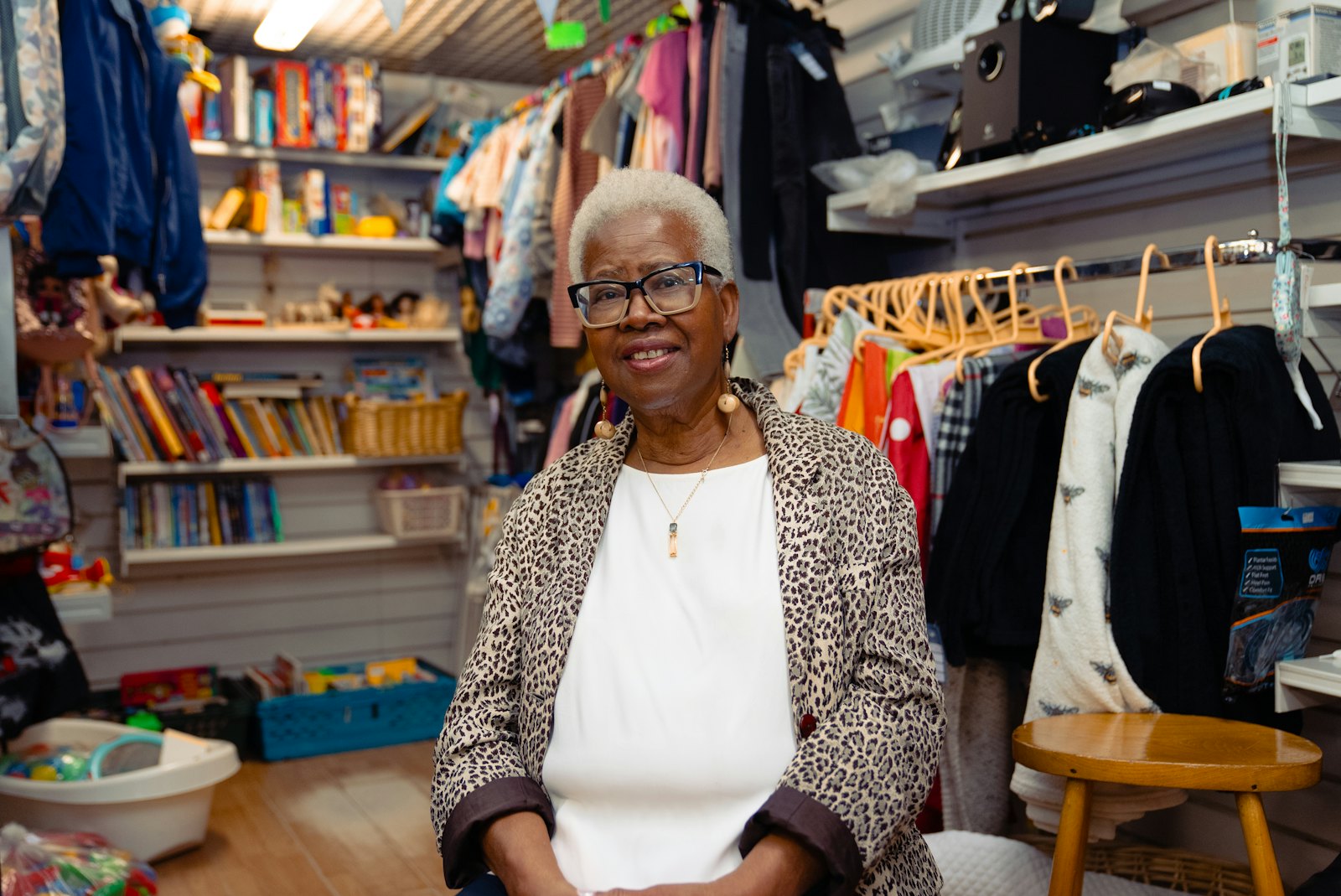 A clothing shop owner smiling among the racks in her store
